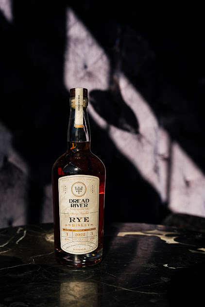 A bottle of Dread River Rye Whiskey on a dark table.