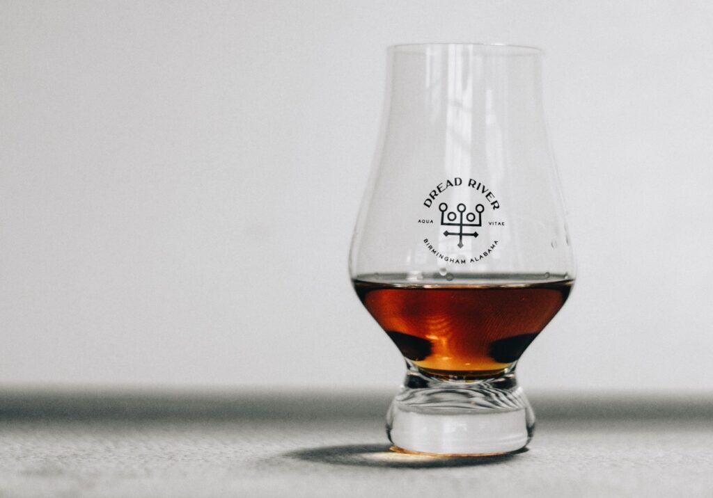 A glass of smooth rum from Dread River Distilling Co., reflecting its rich amber hue and inviting texture.
