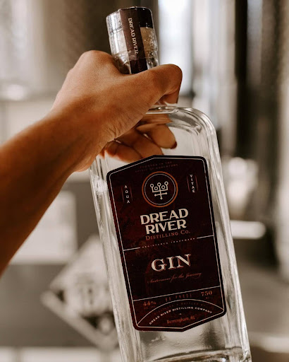 Hand holding Dread River Gin bottle in Birmingham, Alabama, showcasing local distillation craftsmanship.

