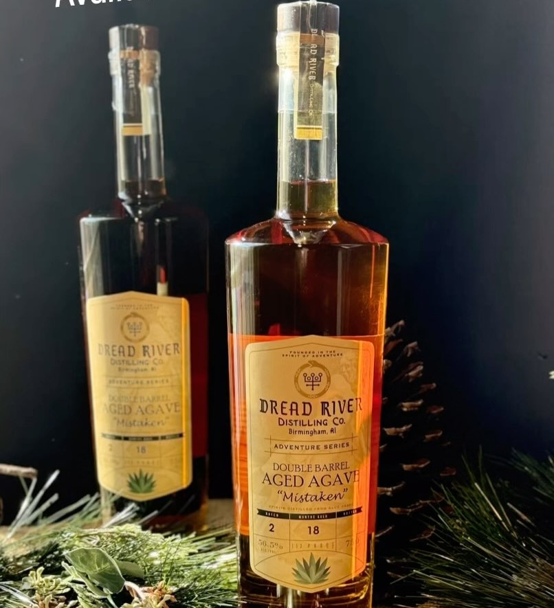 Two bottles of Dread River Distilling Co.'s Double Barrel Aged Agave 'Mistaken,' showcasing the elegant amber liquid and intricate label design.