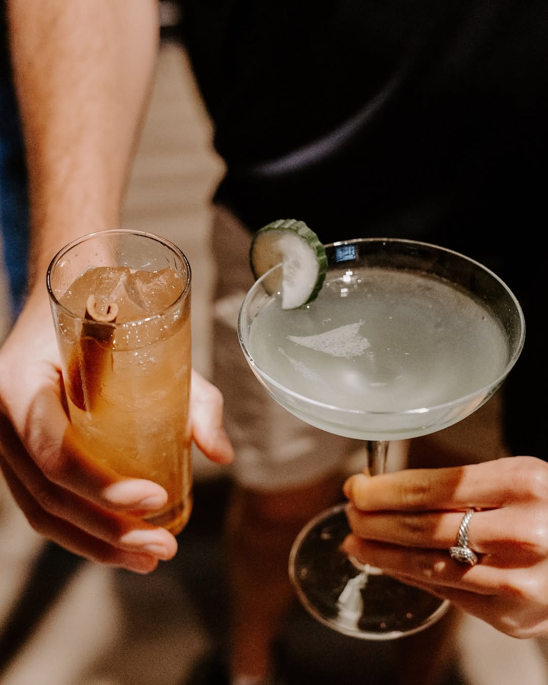 Two hands hold drinks made with whiskey from Dread River Distilling Co.