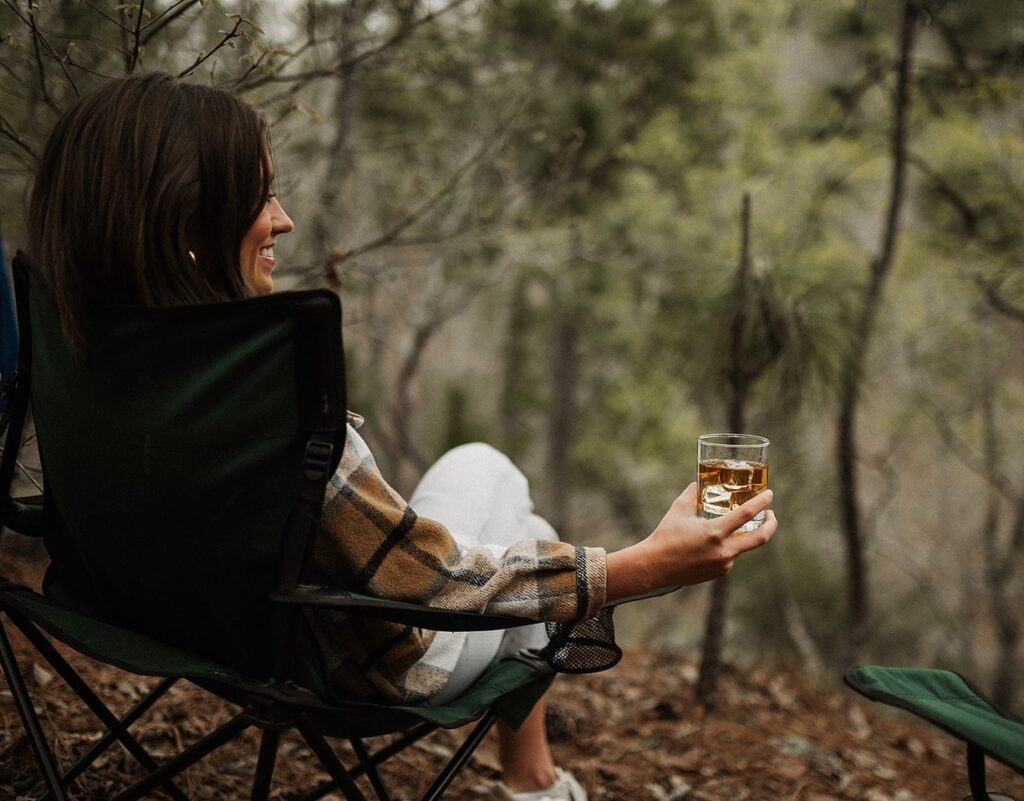 Person enjoying a glass of Dread River whiskey on the rocks, savoring American craftsmanship.
