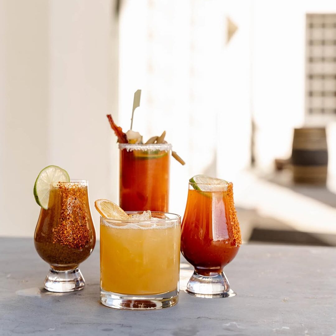 Four whiskey cocktails made with Dread River Spirits arranged on a table.