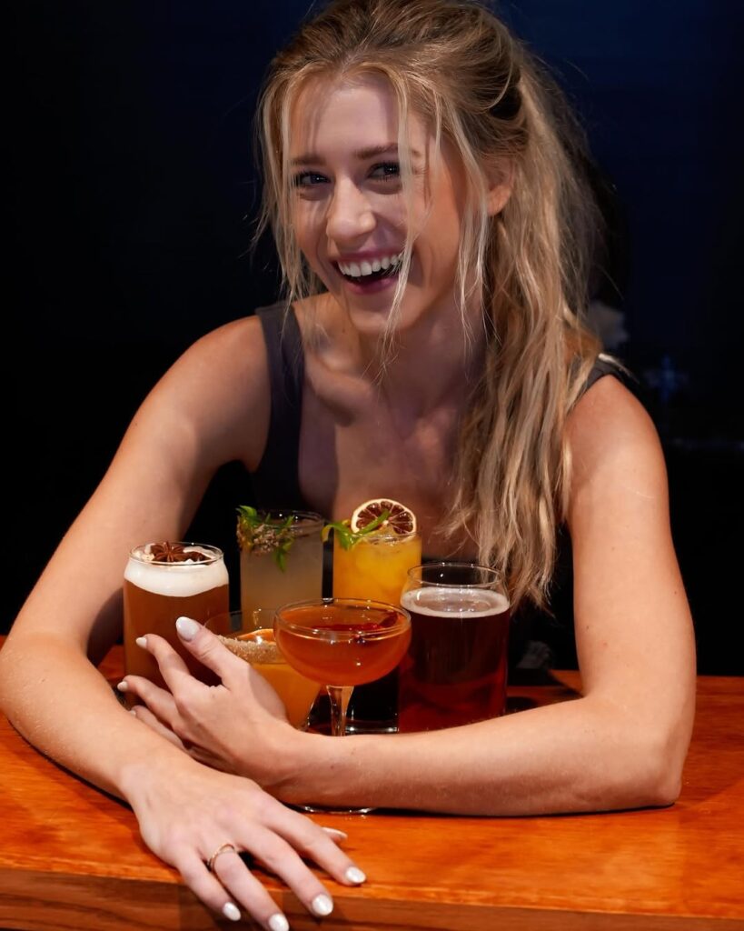 A happy customer of Dread River posing with her cocktails.