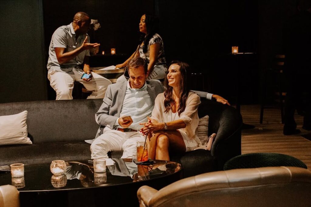A couple on a sofa enjoys cocktails at Dread River Distillery.