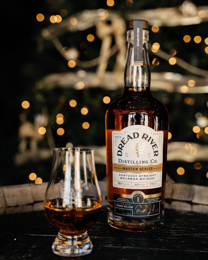 A bottle of Dread River Master Series Bourbon is kept next to a glass with some of the bourbon poured into it.