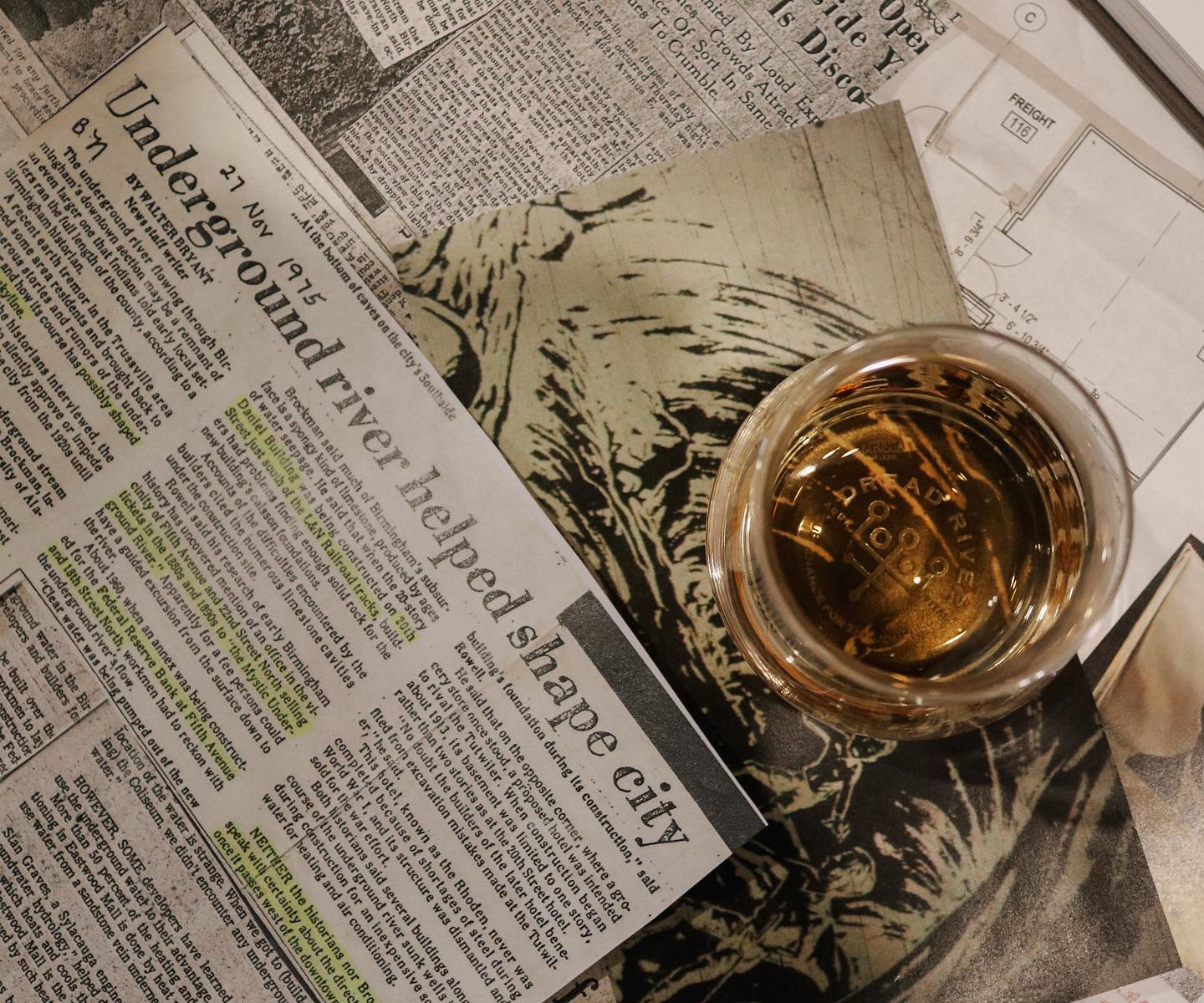 A newspaper with a glass of Dread River bourbon, kept next to it.