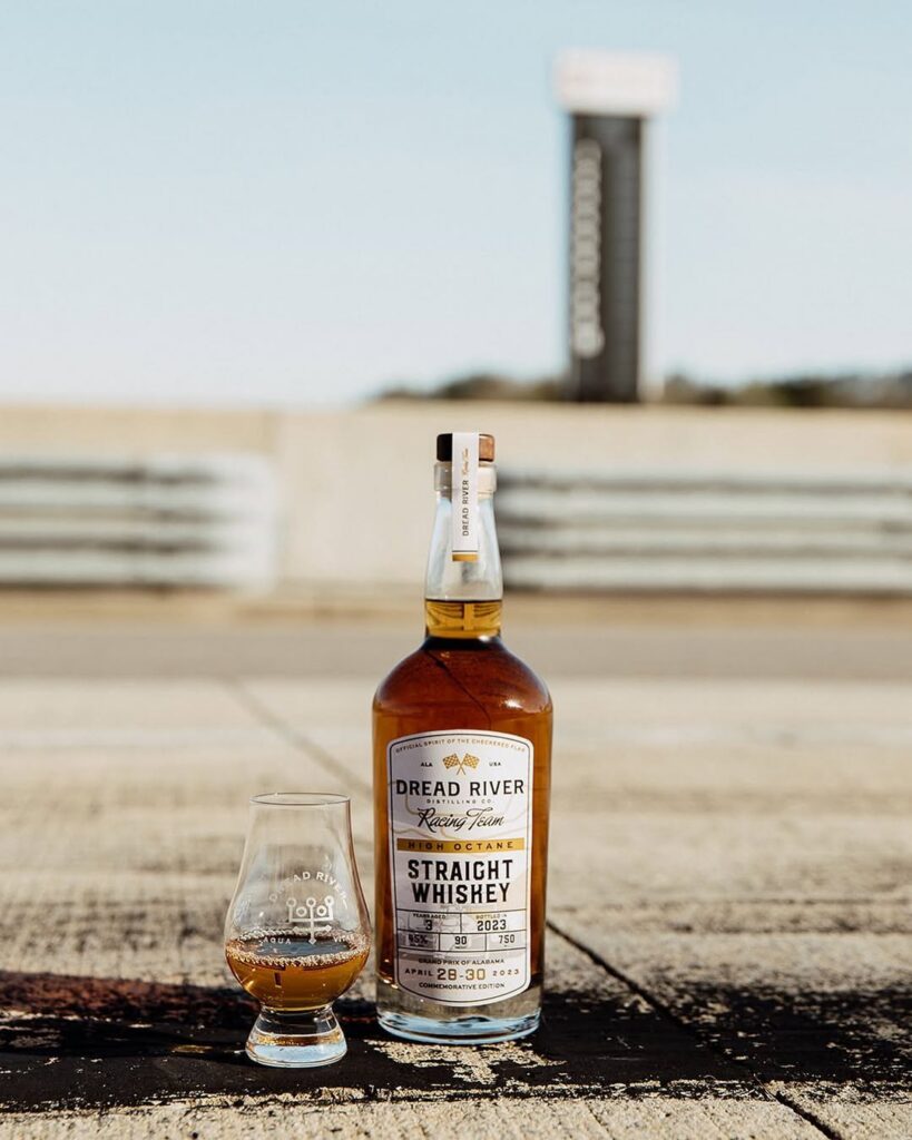 Dread River Straight Whiskey bottle and tasting glass set against an open-air Alabama backdrop.