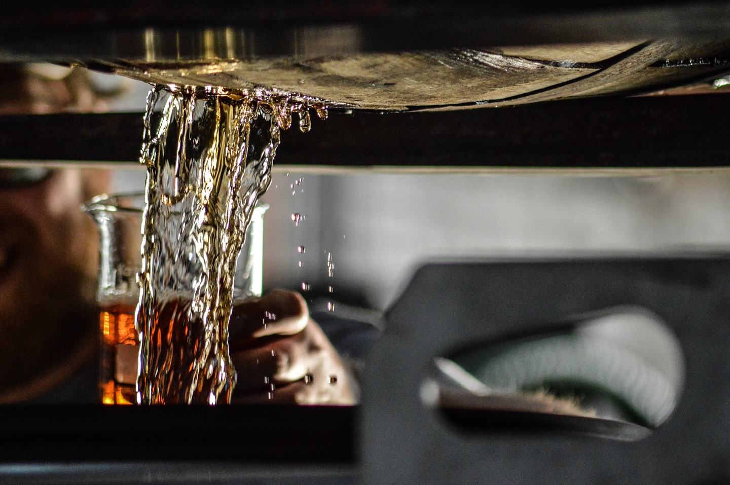 Whiskey flowing from a copper still during distillation at Dread River Distilling Co.