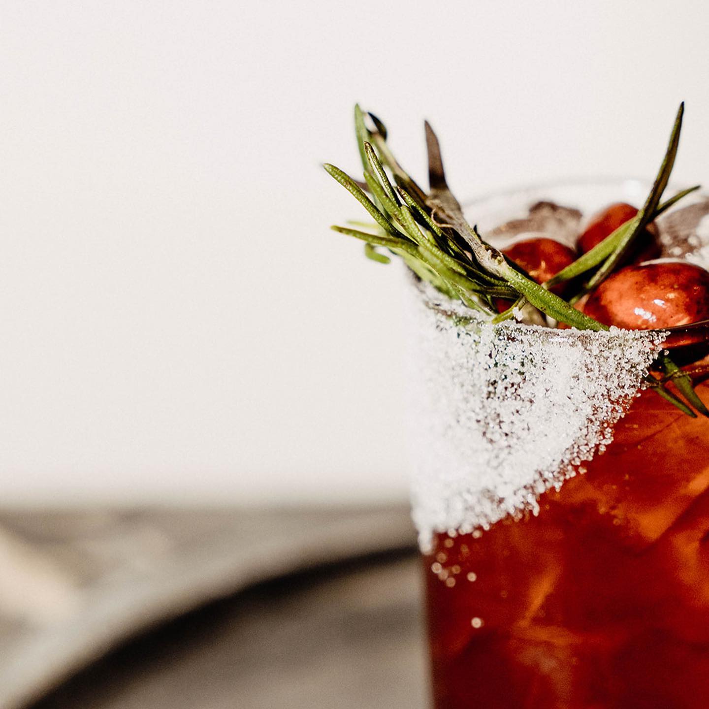 Dread River Bloody Mary with a salted rim, rosemary sprigs, and red cherry tomatoes.