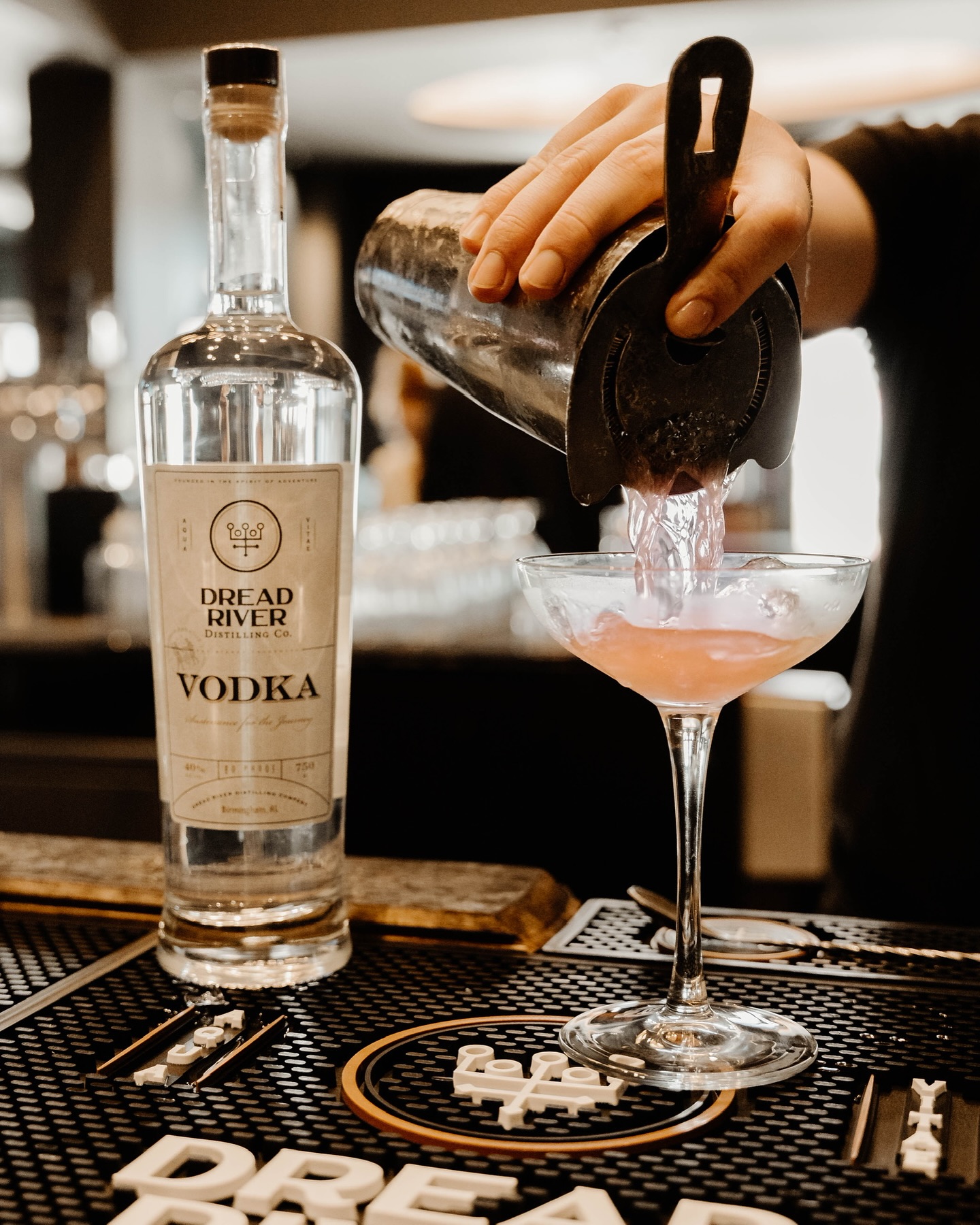 Dread River vodka bottle styled with glassware and garnishes in a modern bar setting.